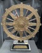 A metal mounted dharma wheel