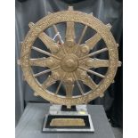 A metal mounted dharma wheel