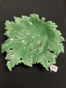 A Continental green glazed pottery leaf dish