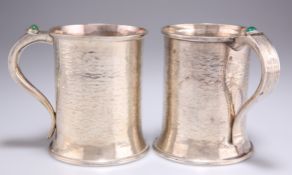 A PAIR OF ARTS AND CRAFTS SILVER MUGS
