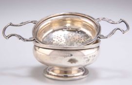 A GEORGE V SILVER TEA STRAINER AND STAND