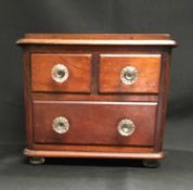A MAHOGANY MINIATURE CHEST OF DRAWERS