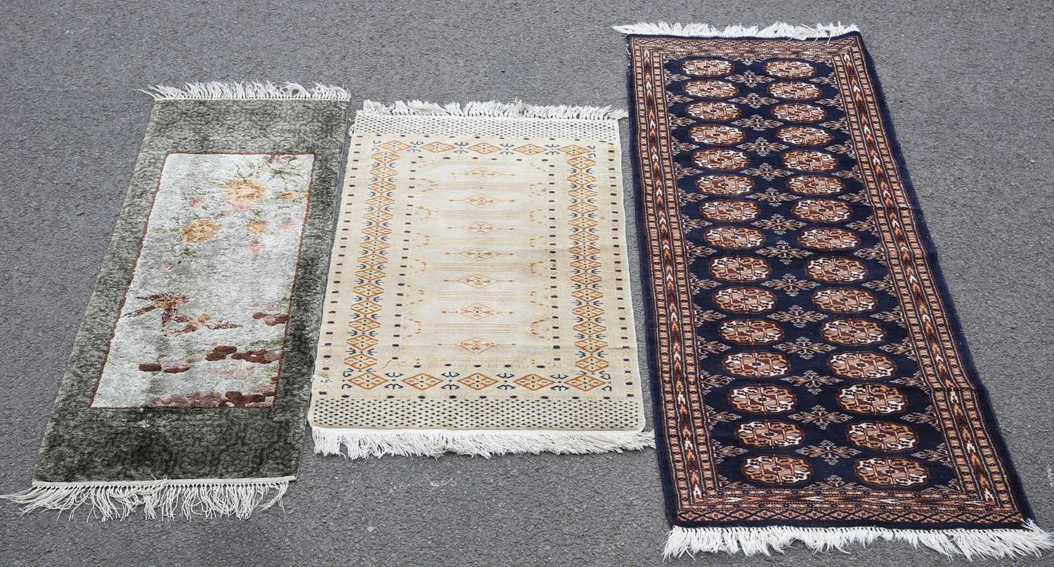 A SMALL CHINESE RUG TOGETHER WITH TWO PAKISTANI RUGS
