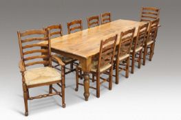 A LARGE COUNTRY PINE DINING TABLE AND TEN OAK AND RUSH-SEATED LADDERBACK DINING CHAIRS