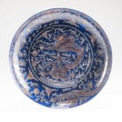 A CHINESE UNDERGLAZE BLUE AND COPPER-RED 'DRAGON' CHARGER
