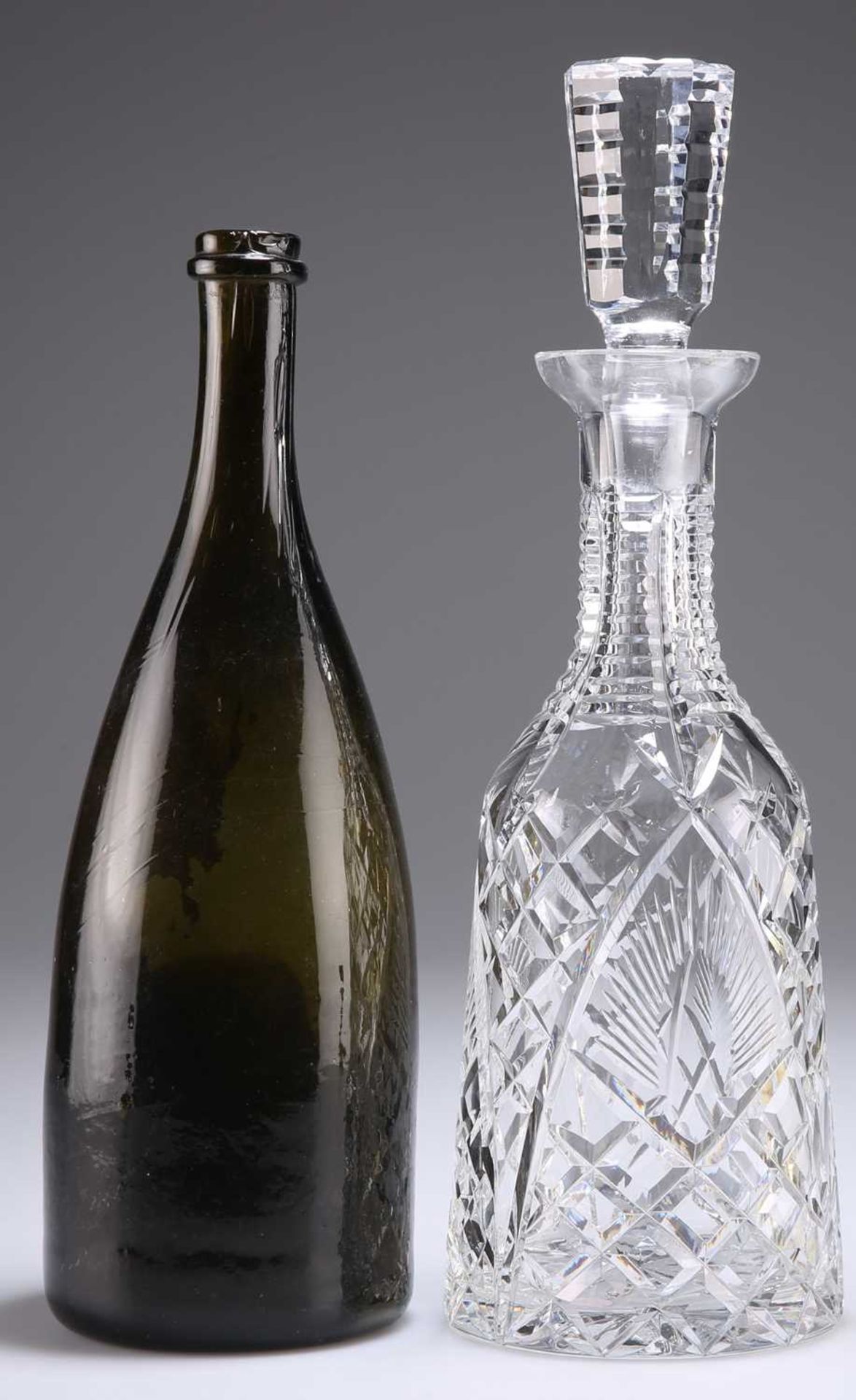A MID-19TH CENTURY GREEN GLASS WINE BOTTLE AND A WATERFORD CUT-GLASS DECANTER AND STOPPER