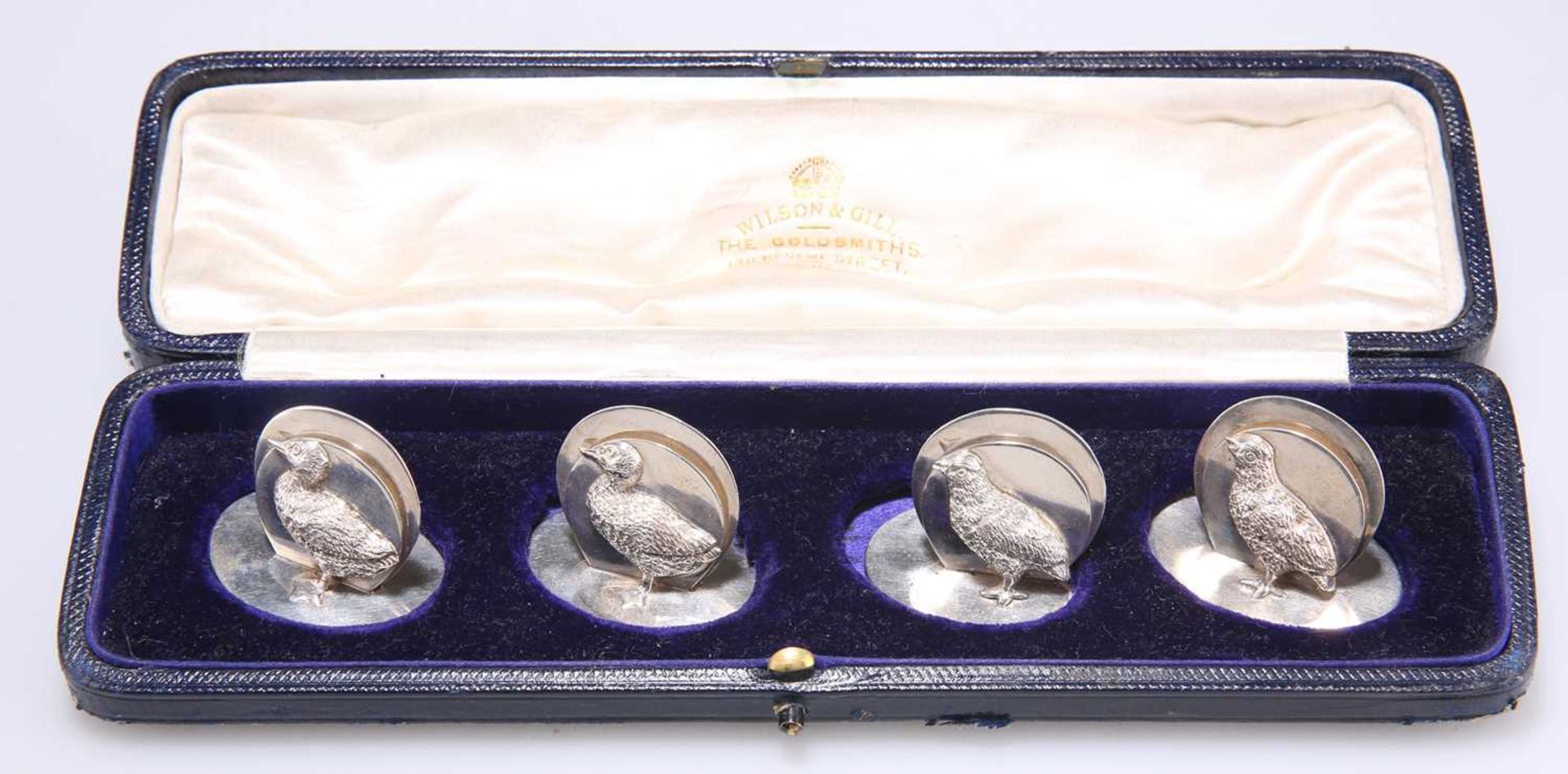 A SET OF FOUR GEORGE V SILVER MENU HOLDERS