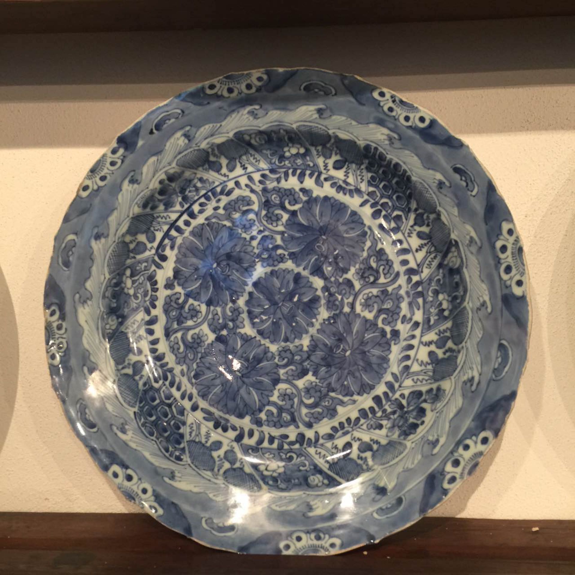 Plat en porcelaine blanche décoré en bleu cobalt sous couvert de motifs floraux aquatiques et de