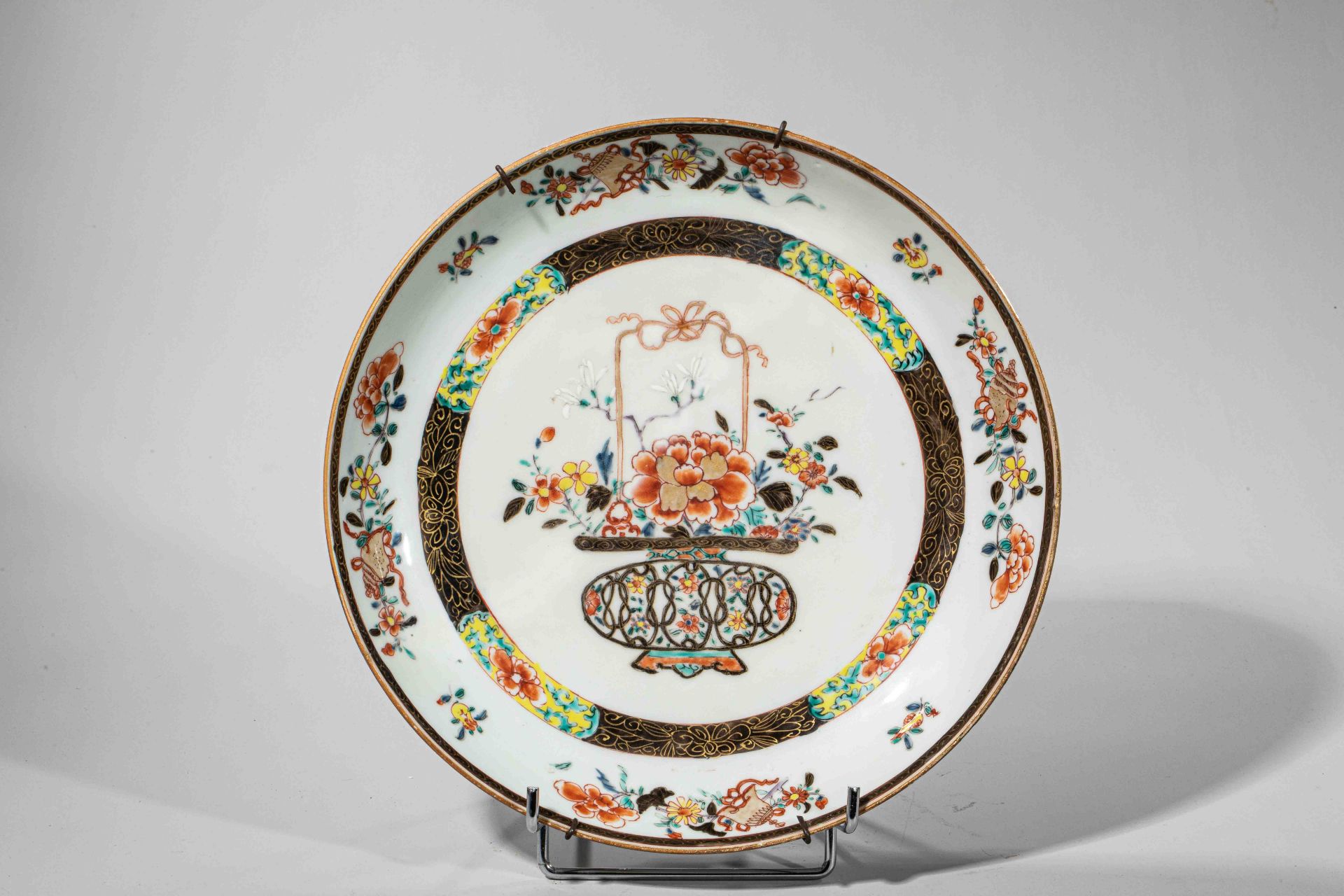 Plat en porcelaine famille rose décoré en émaux polychromes sur la couverte, à décors de panier