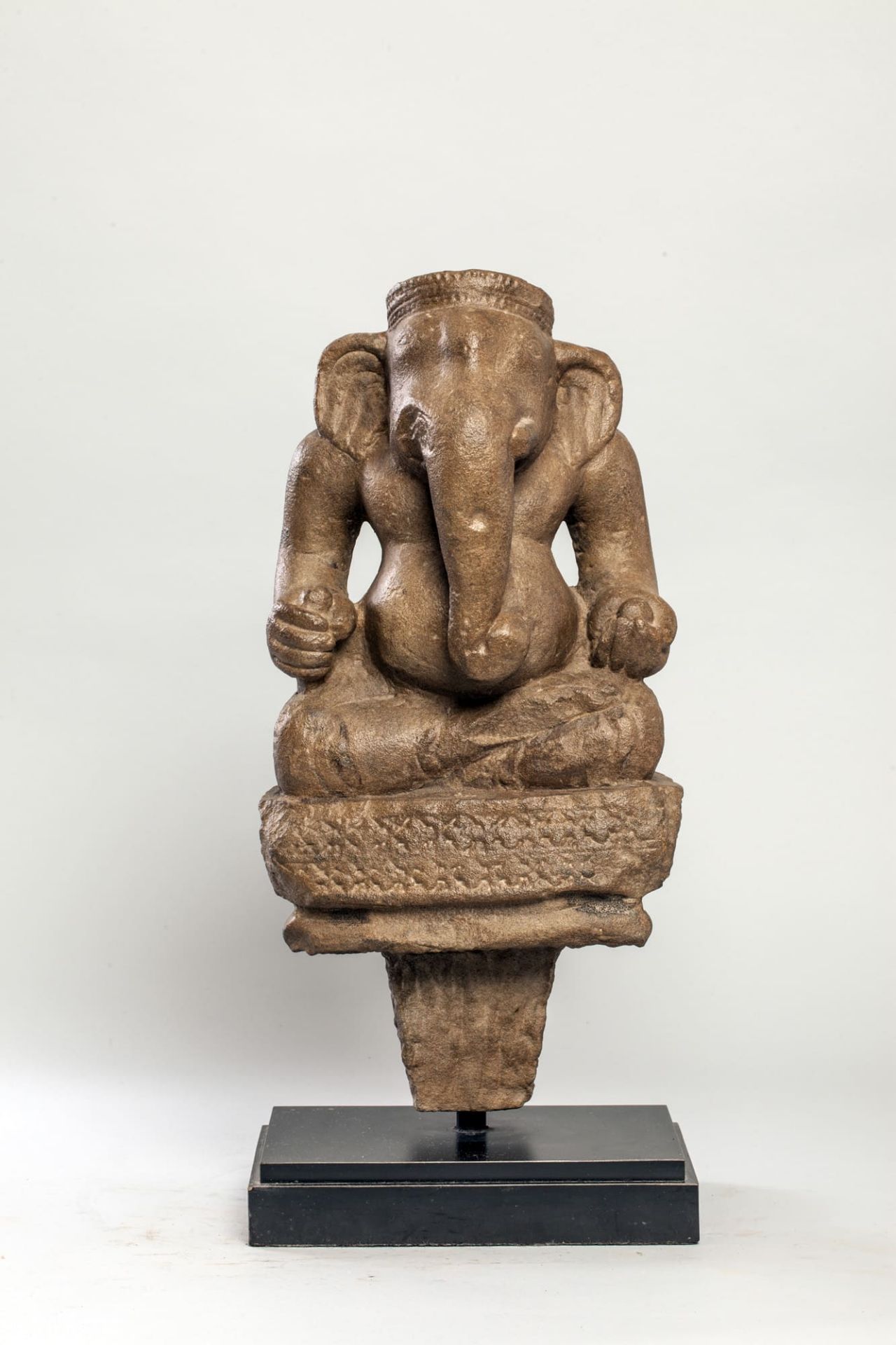 Ganesh assis en Dyana asana, vêtu d’un sampot plissé et noué à la taille , retenu par une large