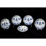 Suite de cinq assiettes en porcelaine blanche décorée en bleu sous couverte de trois personnages