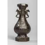 Vase à corps hexagonale moulé d'un décor archaïsant et serti de deux anses florales au col Bronze