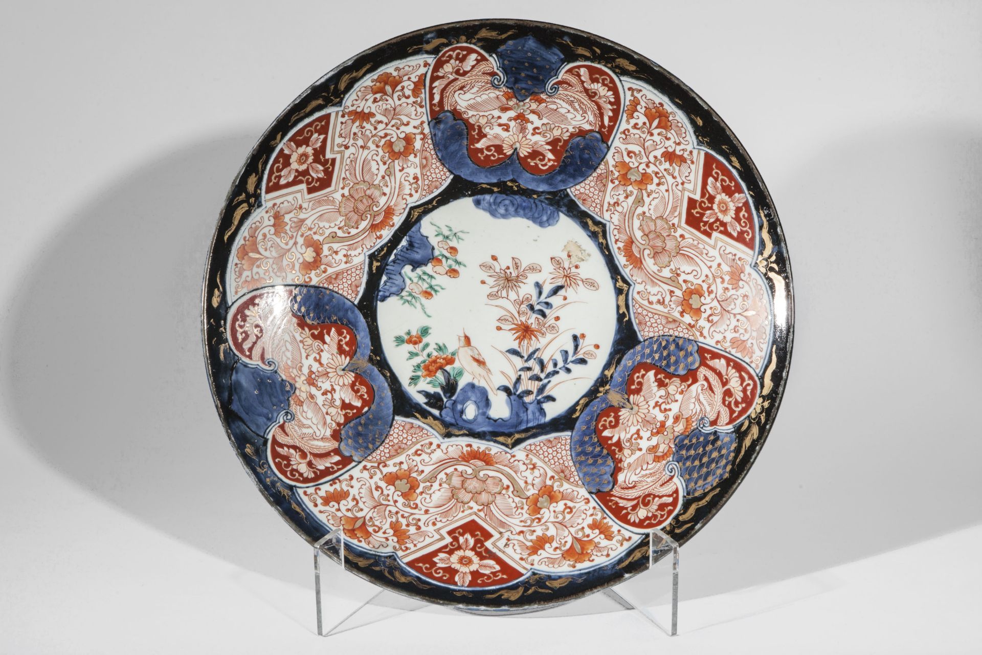 Plat en porcelaine Imari à décor floral en réserve au marli et oiseaux branchés au centre Japon
