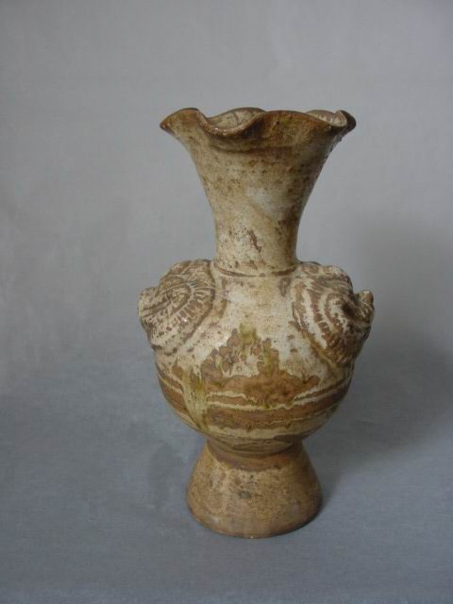 Vase sur haut pied conique à panse globulaire moulé de deux têtes de chimères, à haut col évasé en