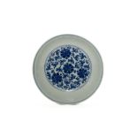 Assiette en porcelaine blanche décorée en fond et au revers du marli, en bleu cobalt sous couverte