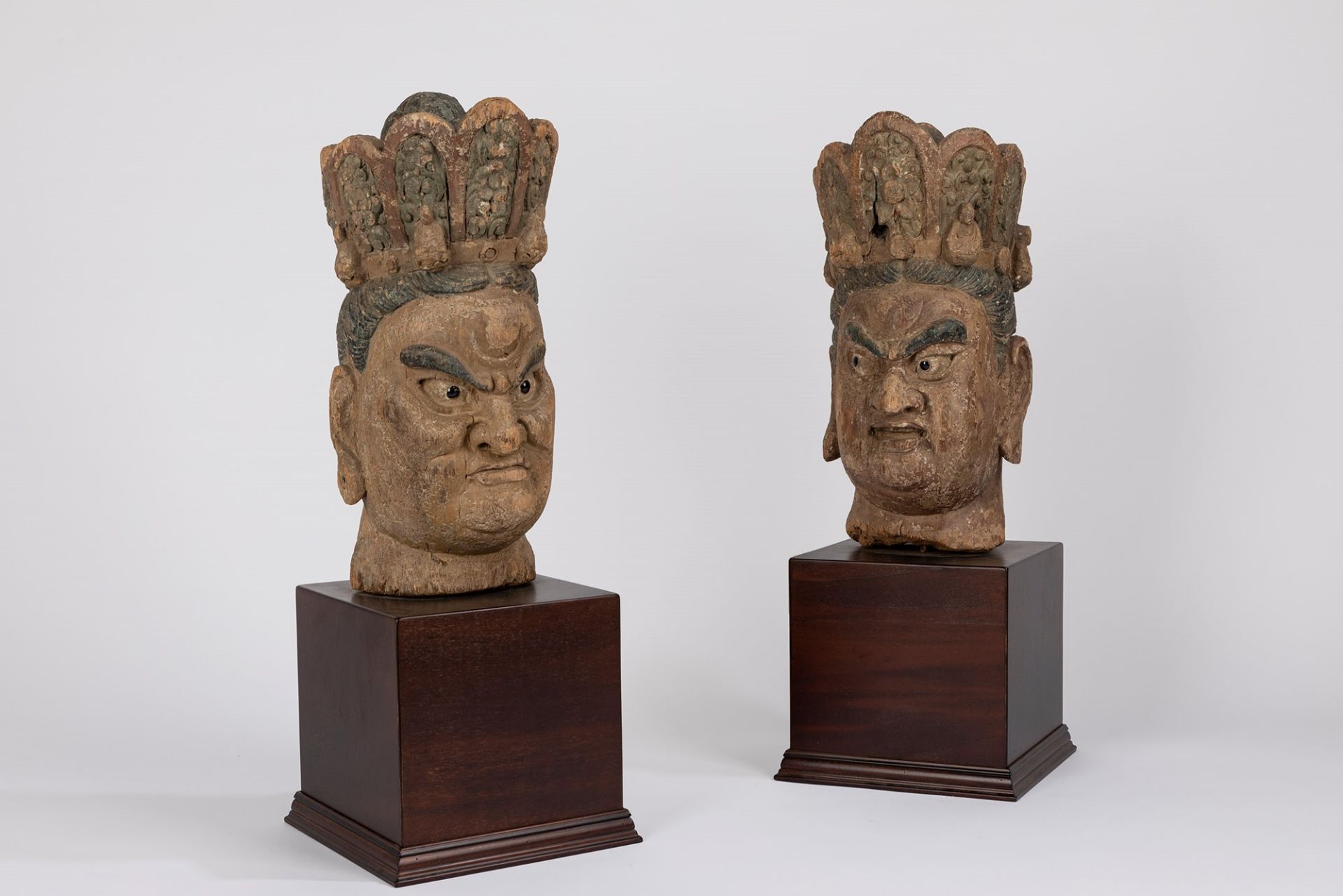 A pair of carved wood heads. China, 19th century
