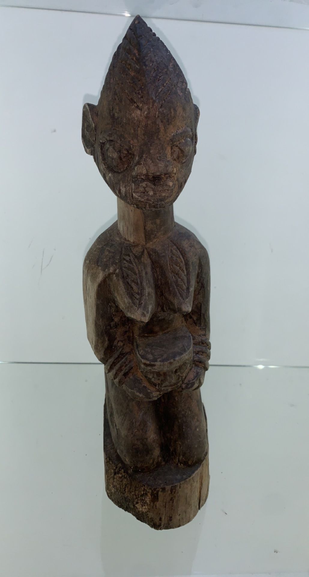 Carved African 20th century figurine kneeling and holding a face - Image 2 of 2