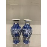 A pair of Blue And white floral design chinease vases with Markings to the bottem.