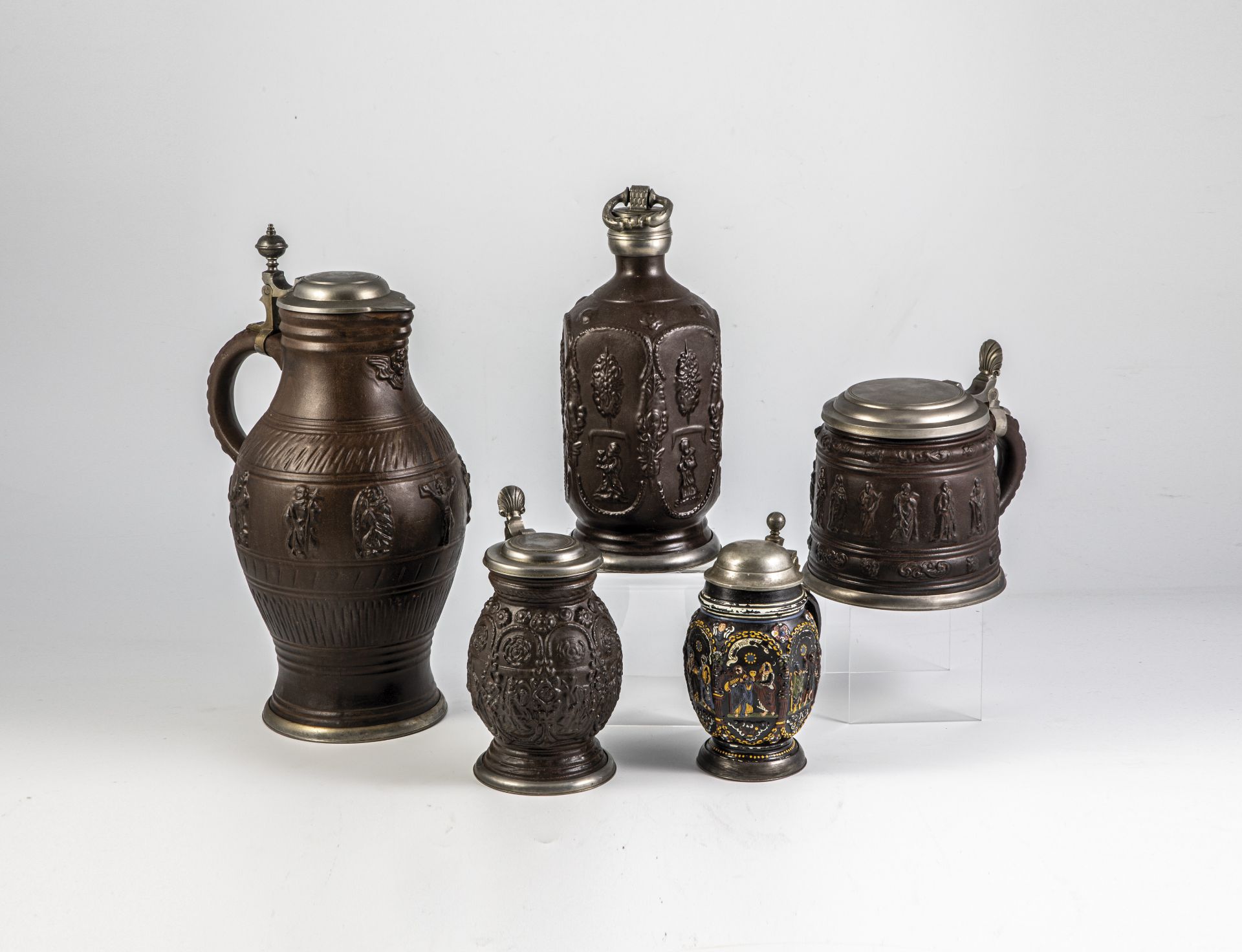 Four jugs and one apothecary bottle with relief overlays