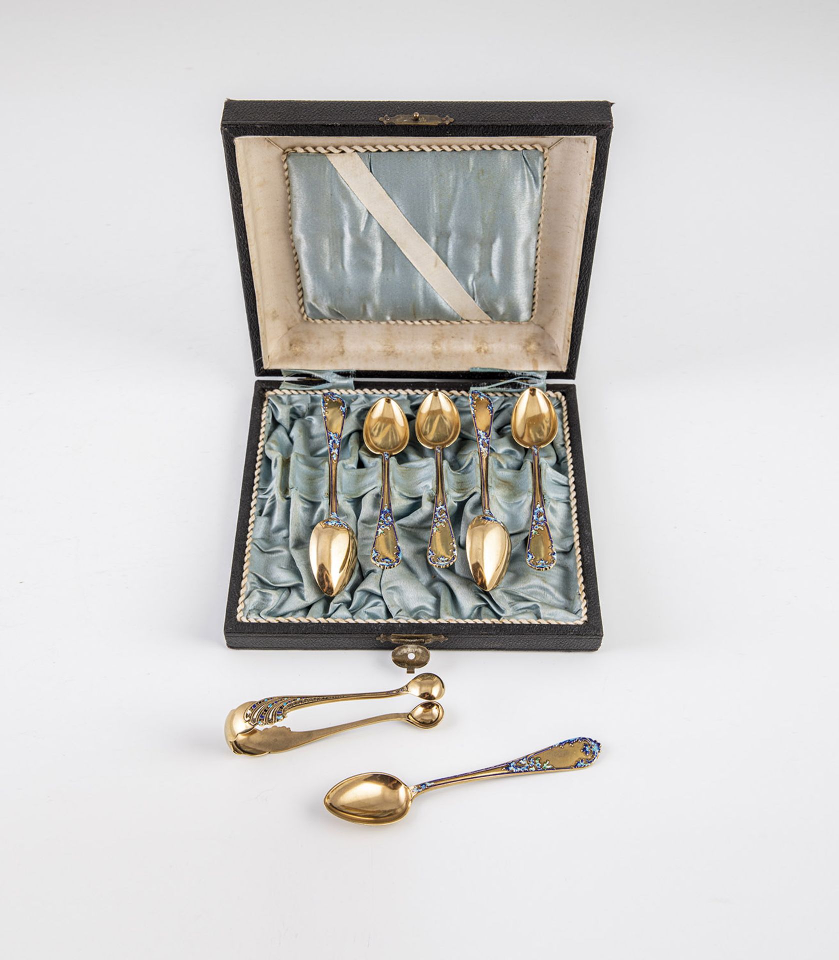 Six teaspoons and sugar tongs with enamel