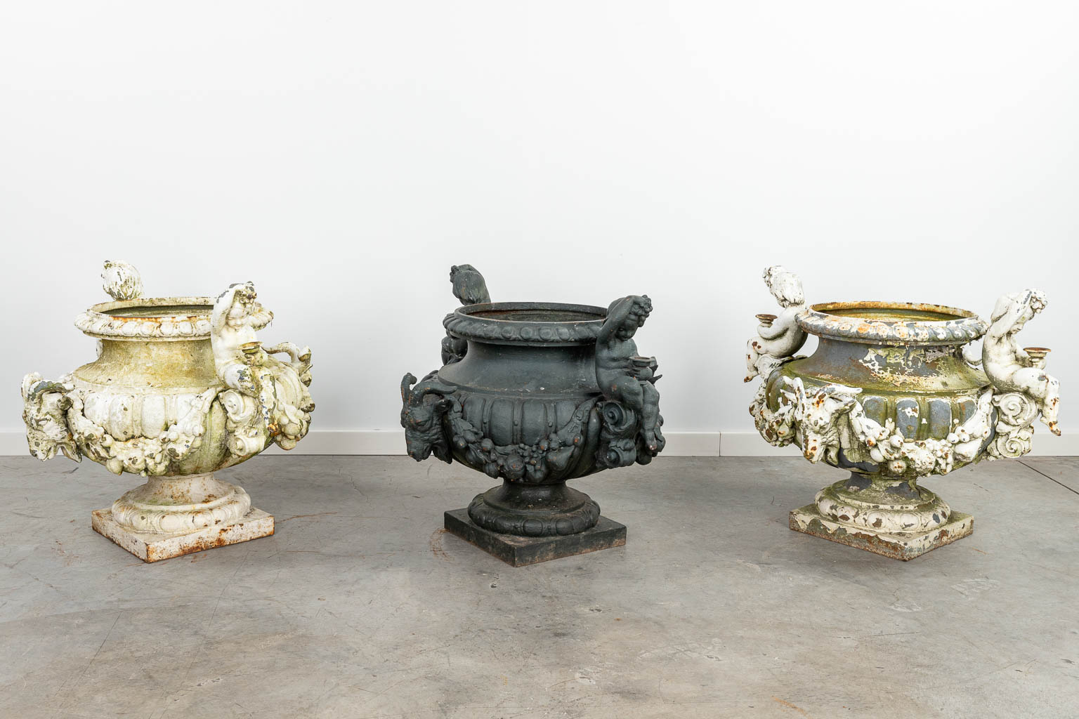 A set of 3 large garden vases made of cast iron, decorated with putti and ram's heads. (H:57cm) - Image 10 of 16