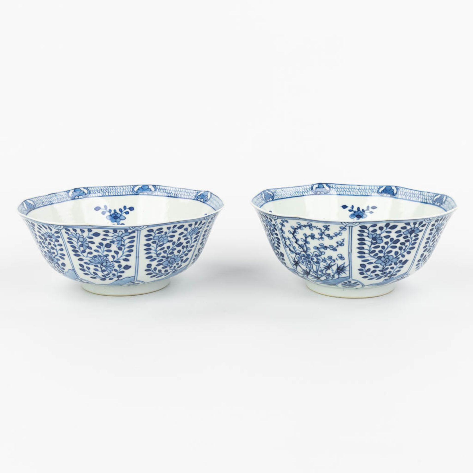 A pair of Chinese bowls made of porcelain with blue-white flower decor and marked Kangxi. (H:7,2cm) - Image 4 of 13