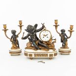 A three-piece mantle clock decorated with putti and a satyr, made of patinated and gilt spelter. (H: