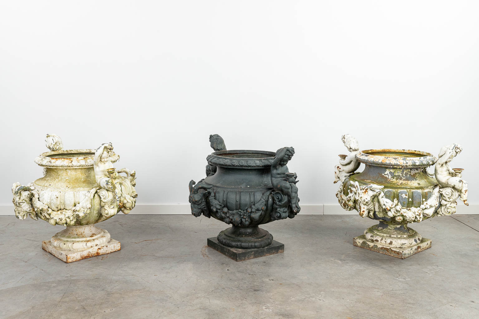 A set of 3 large garden vases made of cast iron, decorated with putti and ram's heads. (H:57cm) - Image 6 of 16