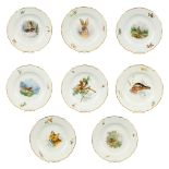 A set of 8 plates with hand-painted images of wild animals and with crossed swords, marked Meissen.