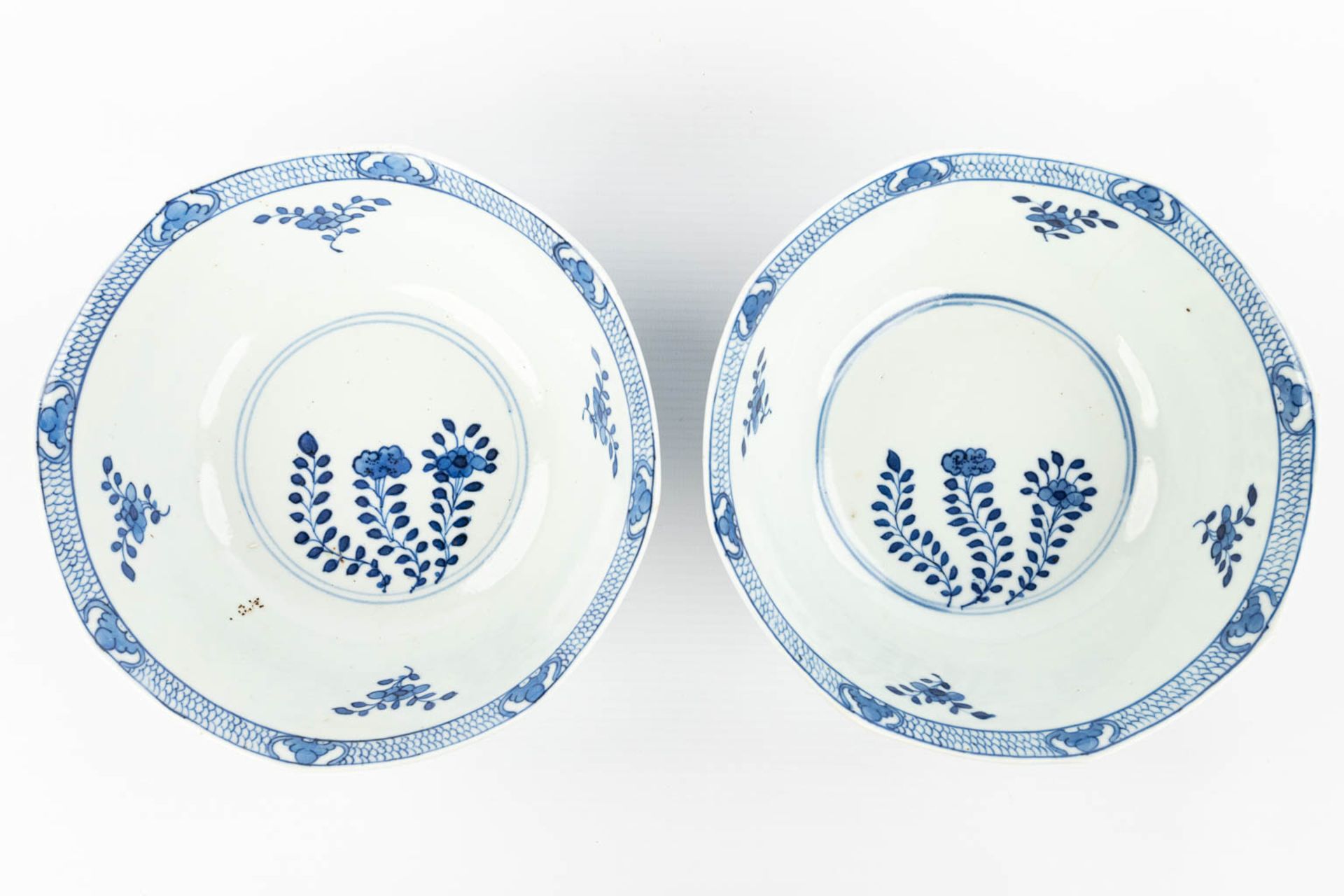 A pair of Chinese bowls made of porcelain with blue-white flower decor and marked Kangxi. (H:7,2cm) - Image 7 of 13