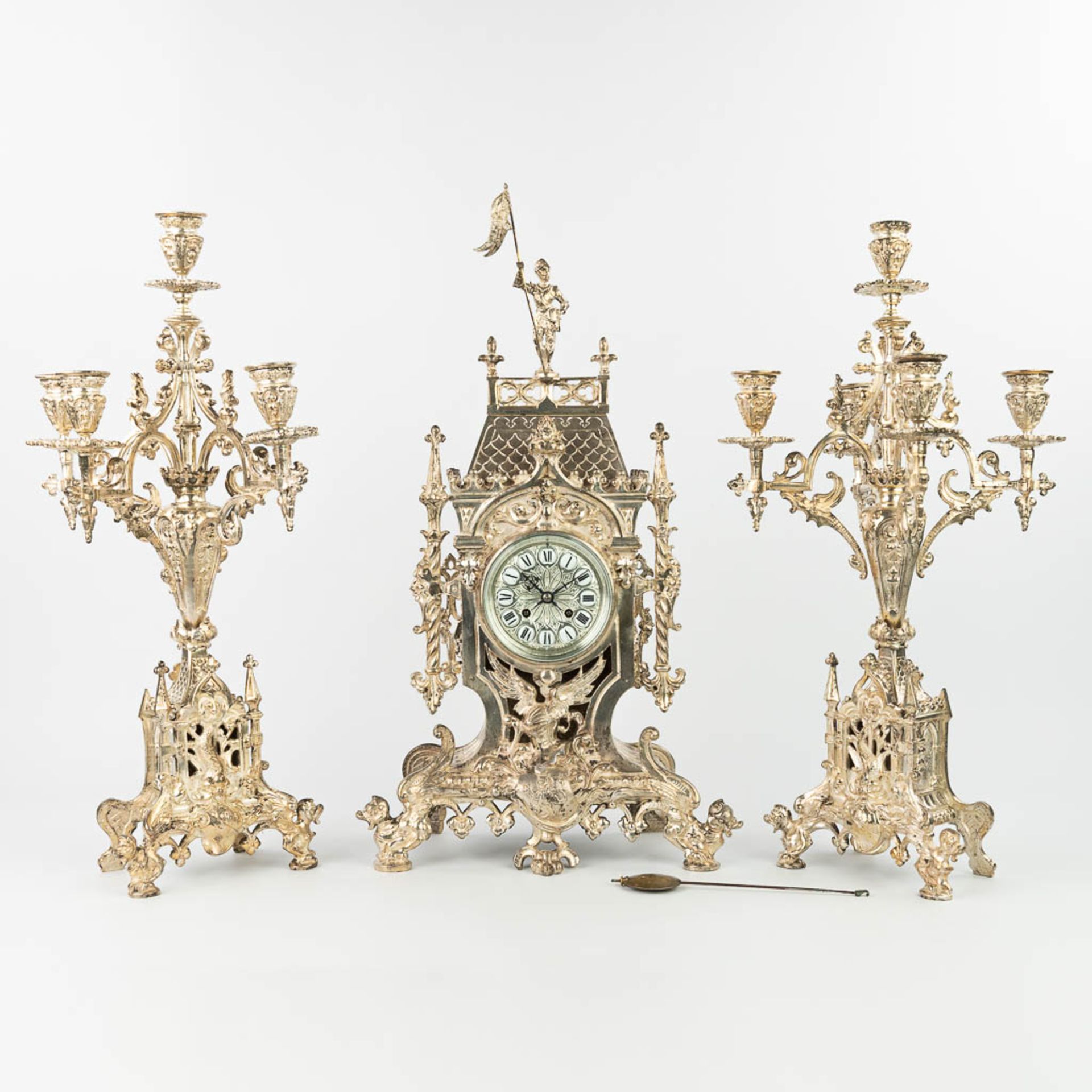 A three-piece garniture clock with candelabra, made of silver-plated bronze in gothic revival style.