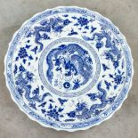 A huge Chinese plate, decorated with a blue-white decor with dragons. 20th century.