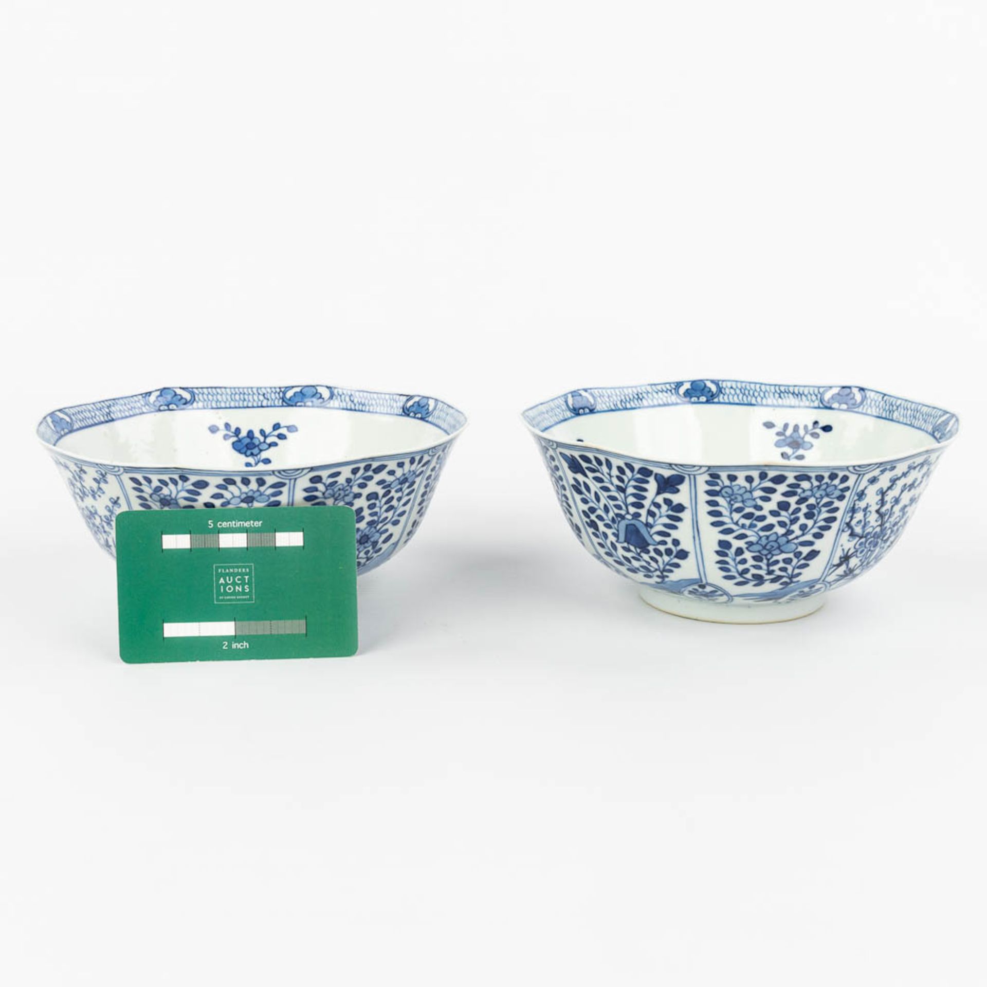 A pair of Chinese bowls made of porcelain with blue-white flower decor and marked Kangxi. (H:7,2cm) - Image 2 of 13