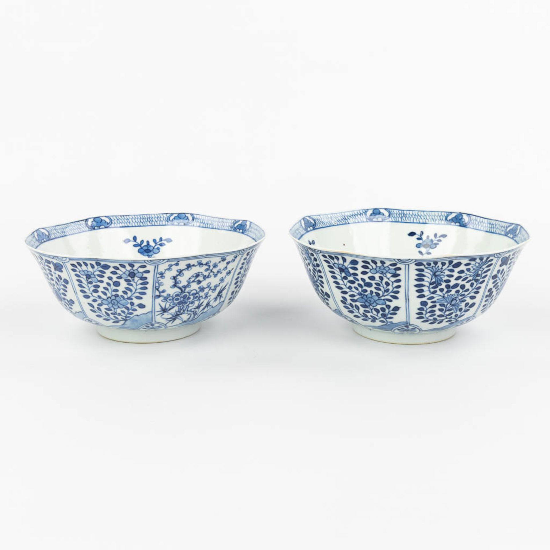 A pair of Chinese bowls made of porcelain with blue-white flower decor and marked Kangxi. (H:7,2cm) - Image 3 of 13