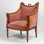 An antique chair in Louis XVI style, with sculptured ram's heads and musical instruments. Walnut. (H