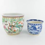 A set of 2 Chinese cache-pots made of porcelain of which 1 has a blue-white decor and the other a de