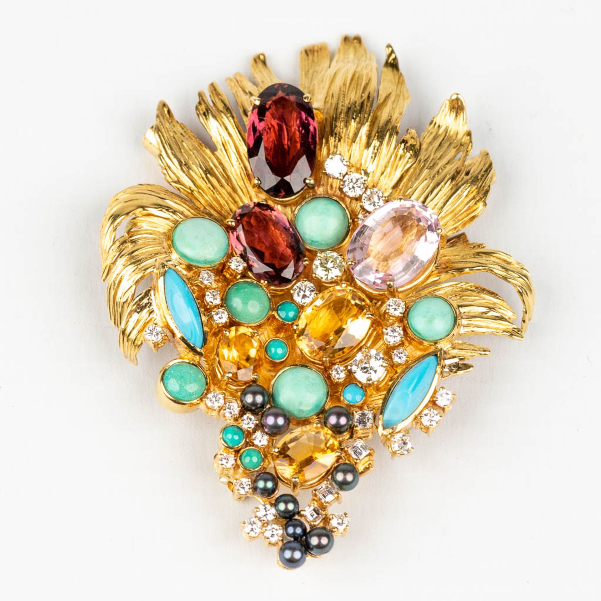A large brooch decorated with multiple different precious stones, diamonds, in an 18 karat yellow go