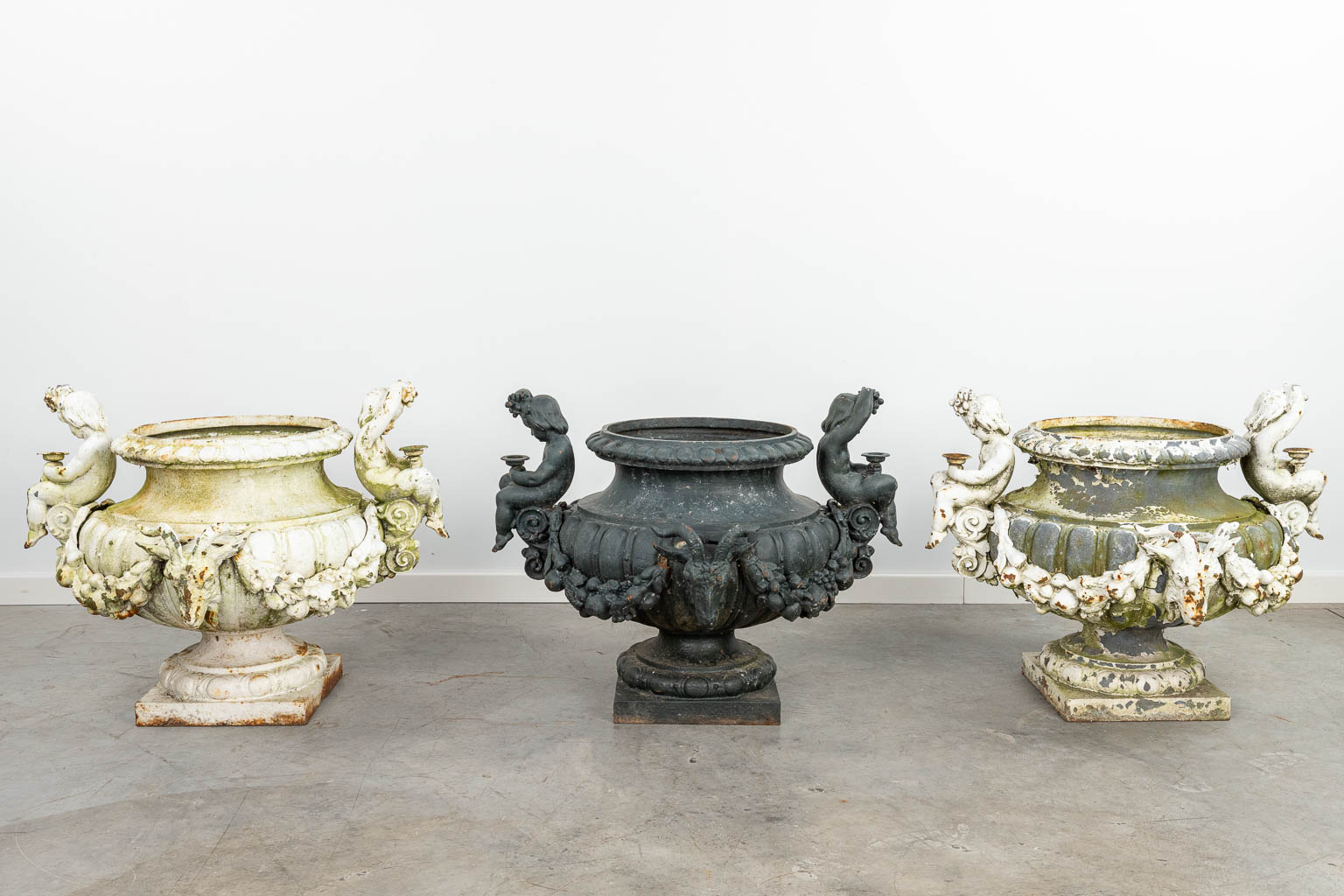 A set of 3 large garden vases made of cast iron, decorated with putti and ram's heads. (H:57cm) - Image 9 of 16