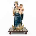 A patinated wood statue of Madonna with a child, standing on the serpent and half-moon.