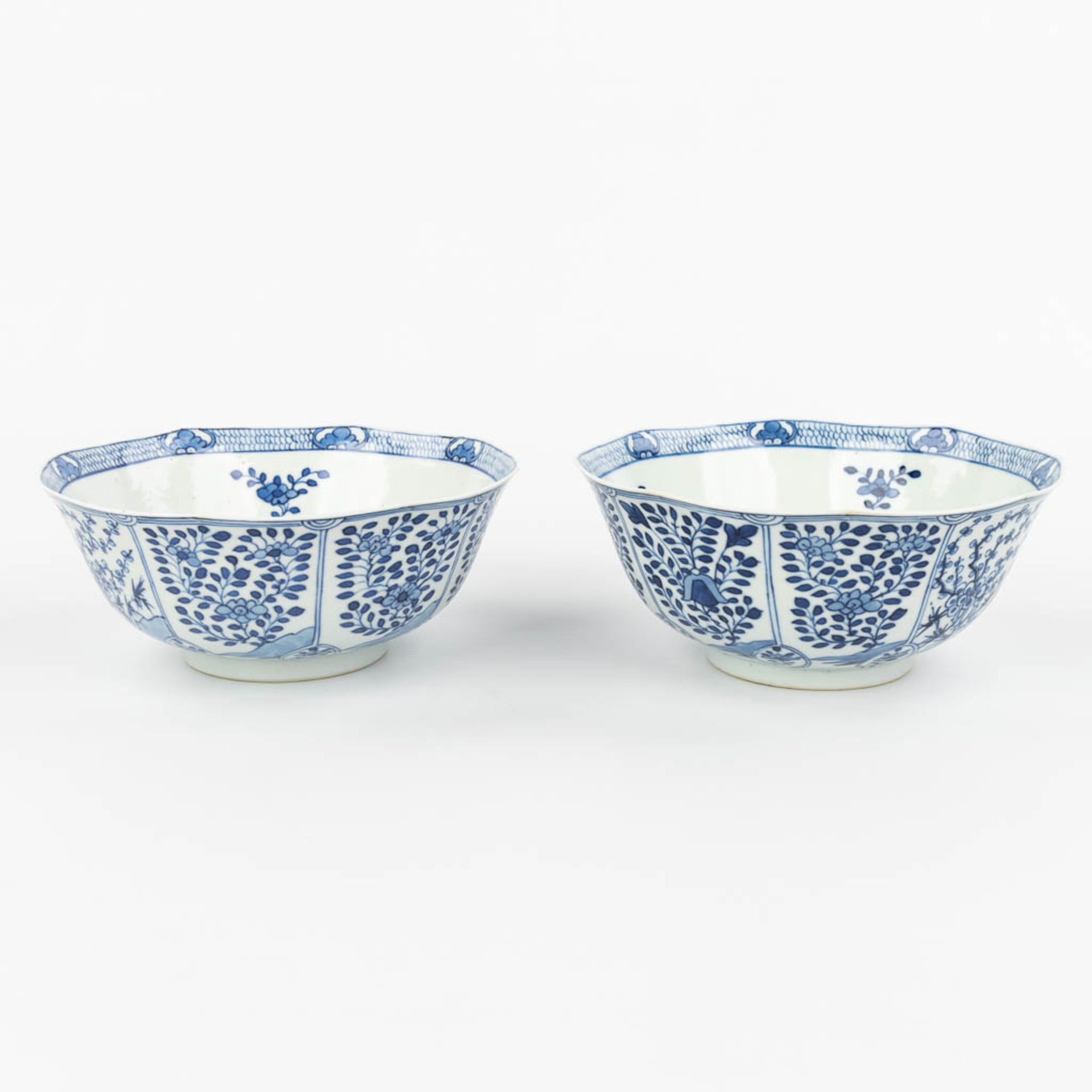 A pair of Chinese bowls made of porcelain with blue-white flower decor and marked Kangxi. (H:7,2cm)