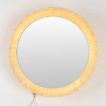 A round mirror, acrylic and glass and made by Deknudt.
