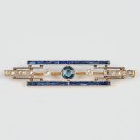 A small brooch made of yellow and white gold in art deco style, with blue sapphires.
