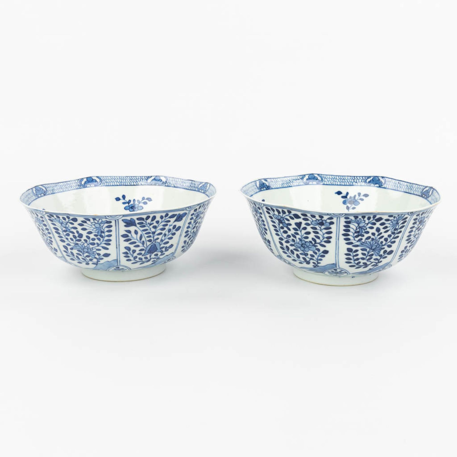 A pair of Chinese bowls made of porcelain with blue-white flower decor and marked Kangxi. (H:7,2cm) - Image 12 of 13