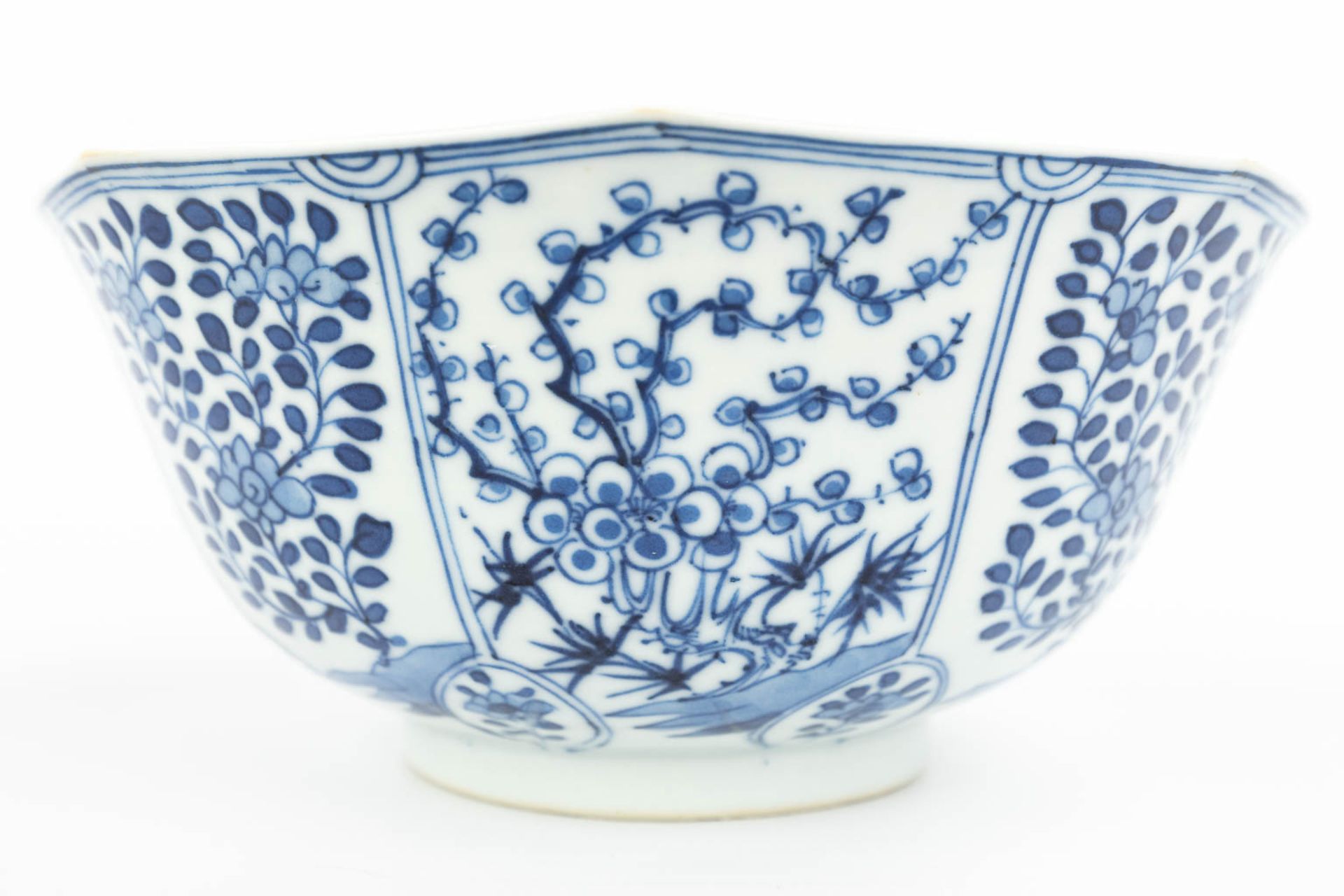 A pair of Chinese bowls made of porcelain with blue-white flower decor and marked Kangxi. (H:7,2cm) - Image 6 of 13
