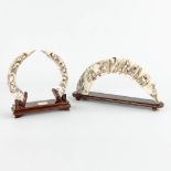 A collection of 2 sculptured horns or bone, mounted on a wood stand. (H:19cm)