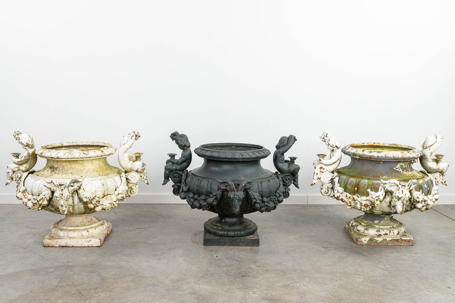 A set of 3 large garden vases made of cast iron, decorated with putti and ram's heads. (H:57cm) - Image 4 of 16