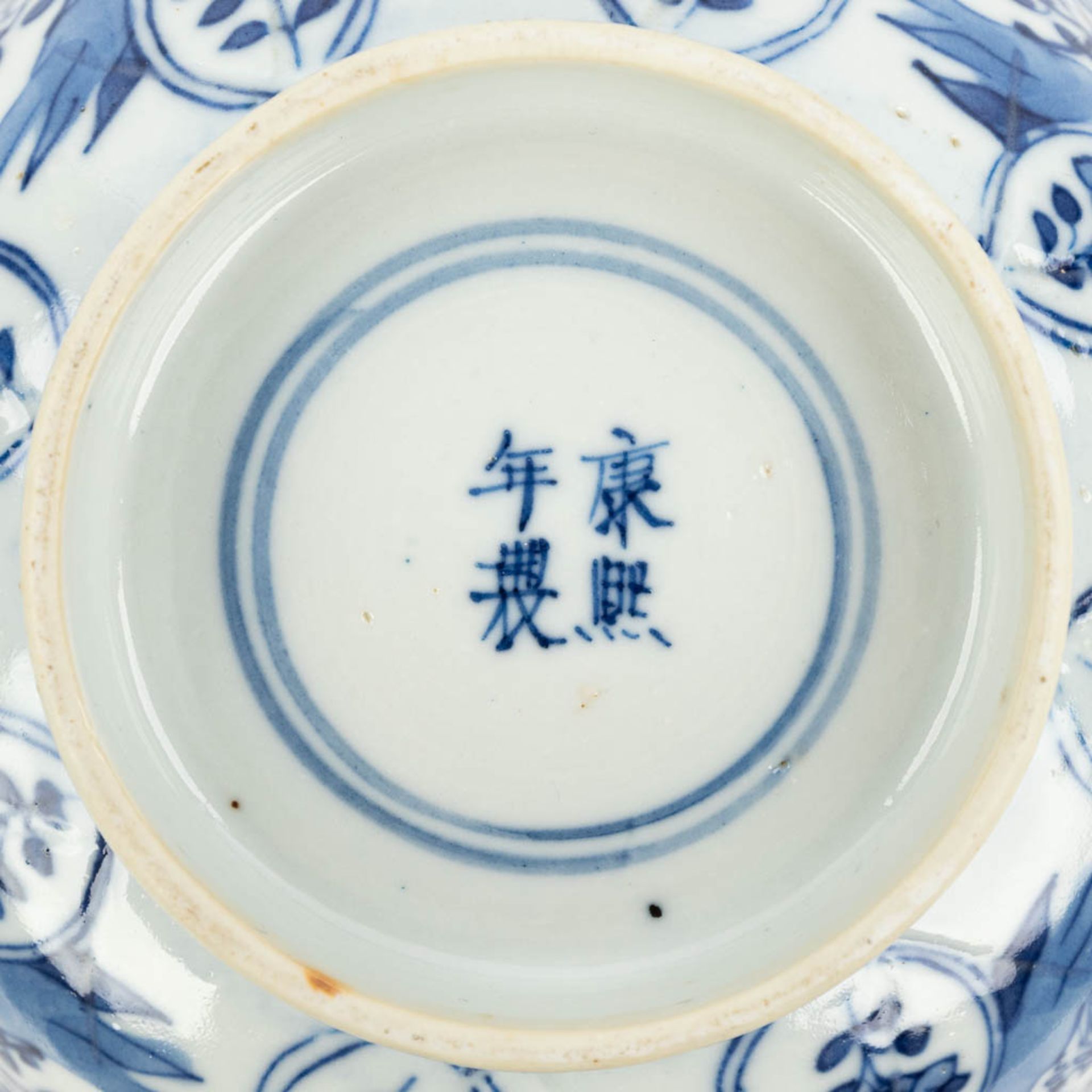 A pair of Chinese bowls made of porcelain with blue-white flower decor and marked Kangxi. (H:7,2cm) - Image 5 of 13