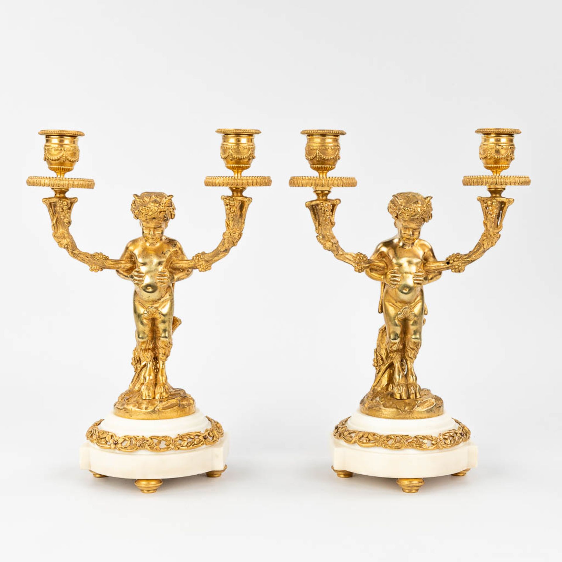 A pair of candelabra with Satyr figurines, made of gold-plated bronze. (13 x 21 x 30,5cm)