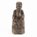 A small and antique wood sculptured statue of a Chinese figurine. (9 x 9,5 x 22 cm)