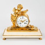 A mantle clock made of bronze on a white marble base and decorated with a putto (16 x 36 x 33cm)